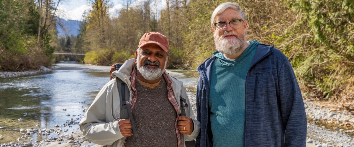 Image of two men standing next to a river