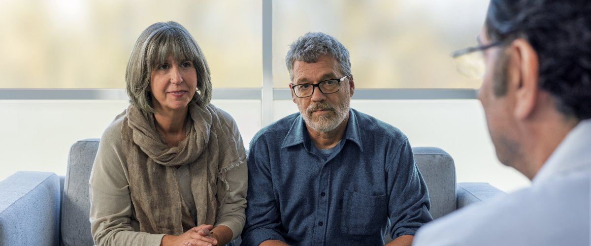 Image of a man and his care partner talking to a doctor